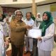 Pj Bupati Aceh Utara Mahyuzar menyerahkan penghargaan kepada nakes